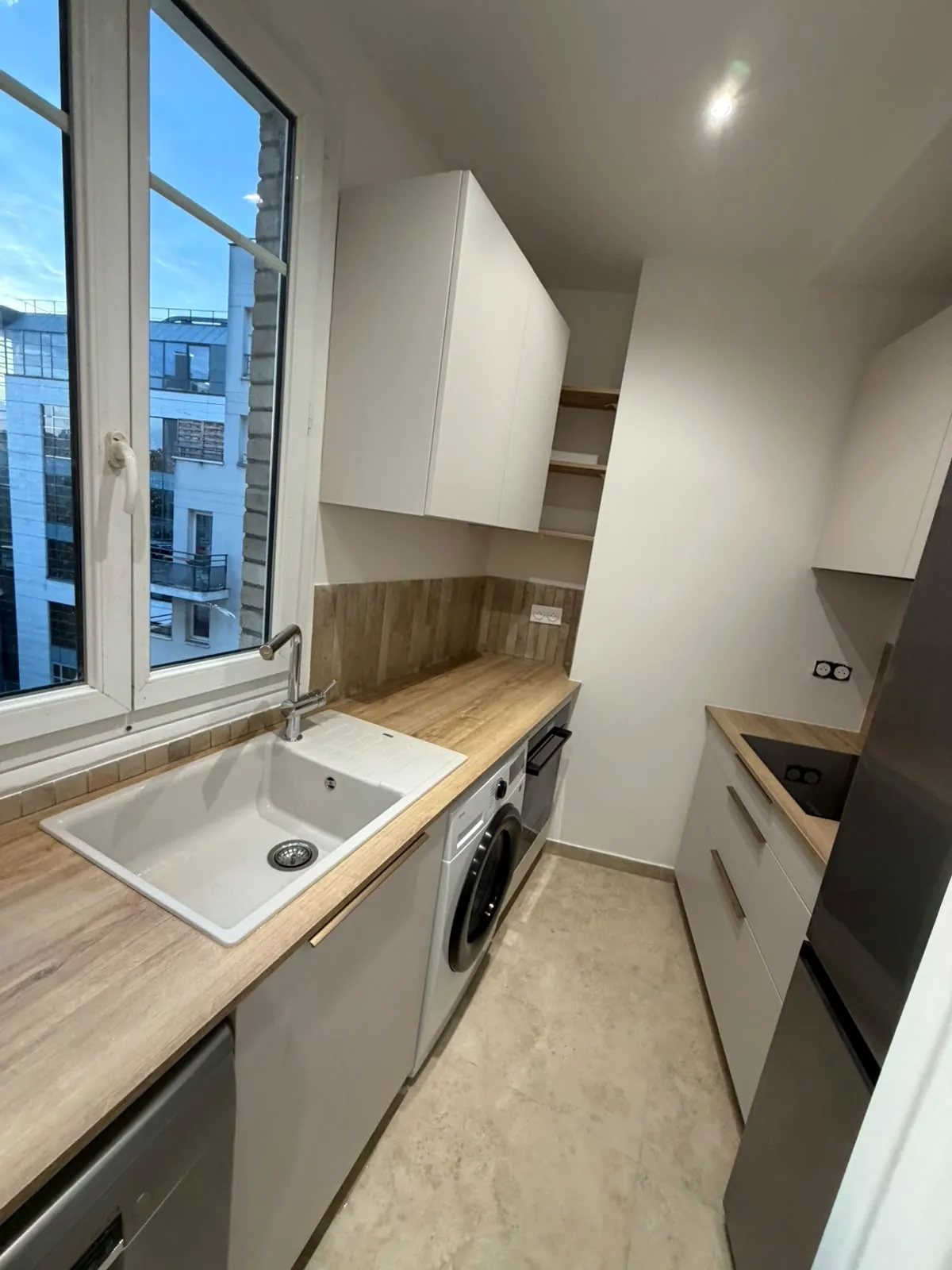 Cuisine blanche, évier sous la fenêtre
