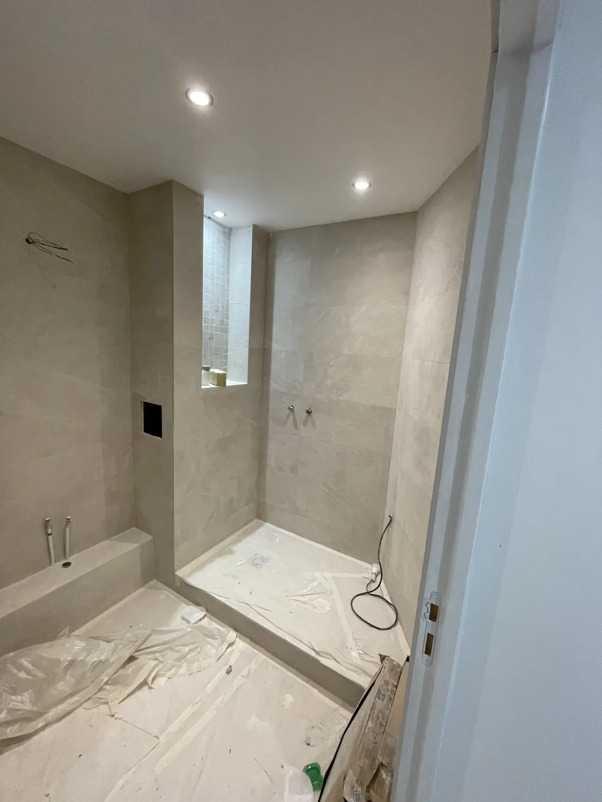 Pendant : Étanchéité, receveur, faïence grand format et niche dans la douche.